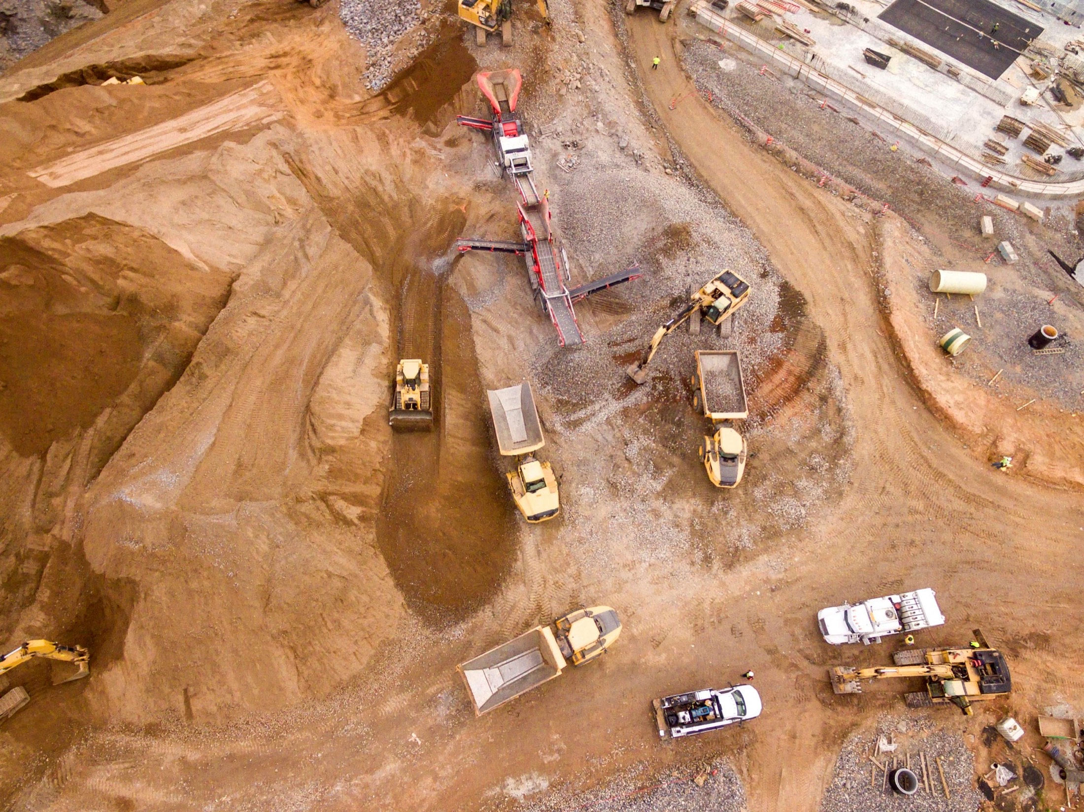 Aerial view of dump trucks and machinery at an open mine site