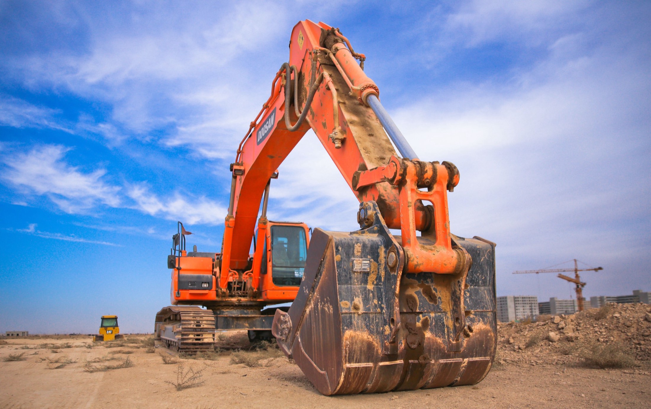 An excavator working on site under a blue sky