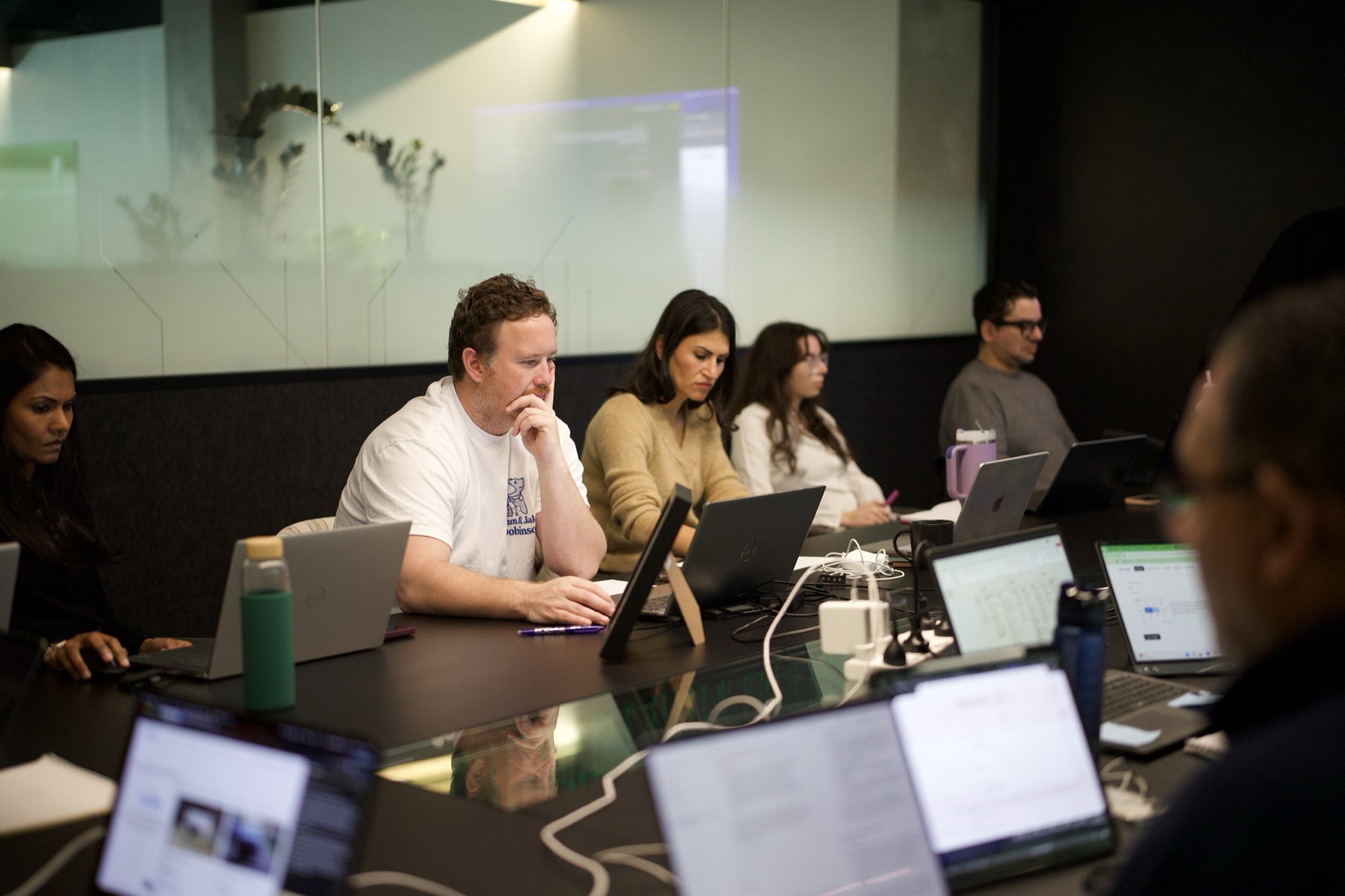 A business team working alongside AI tools on their laptops