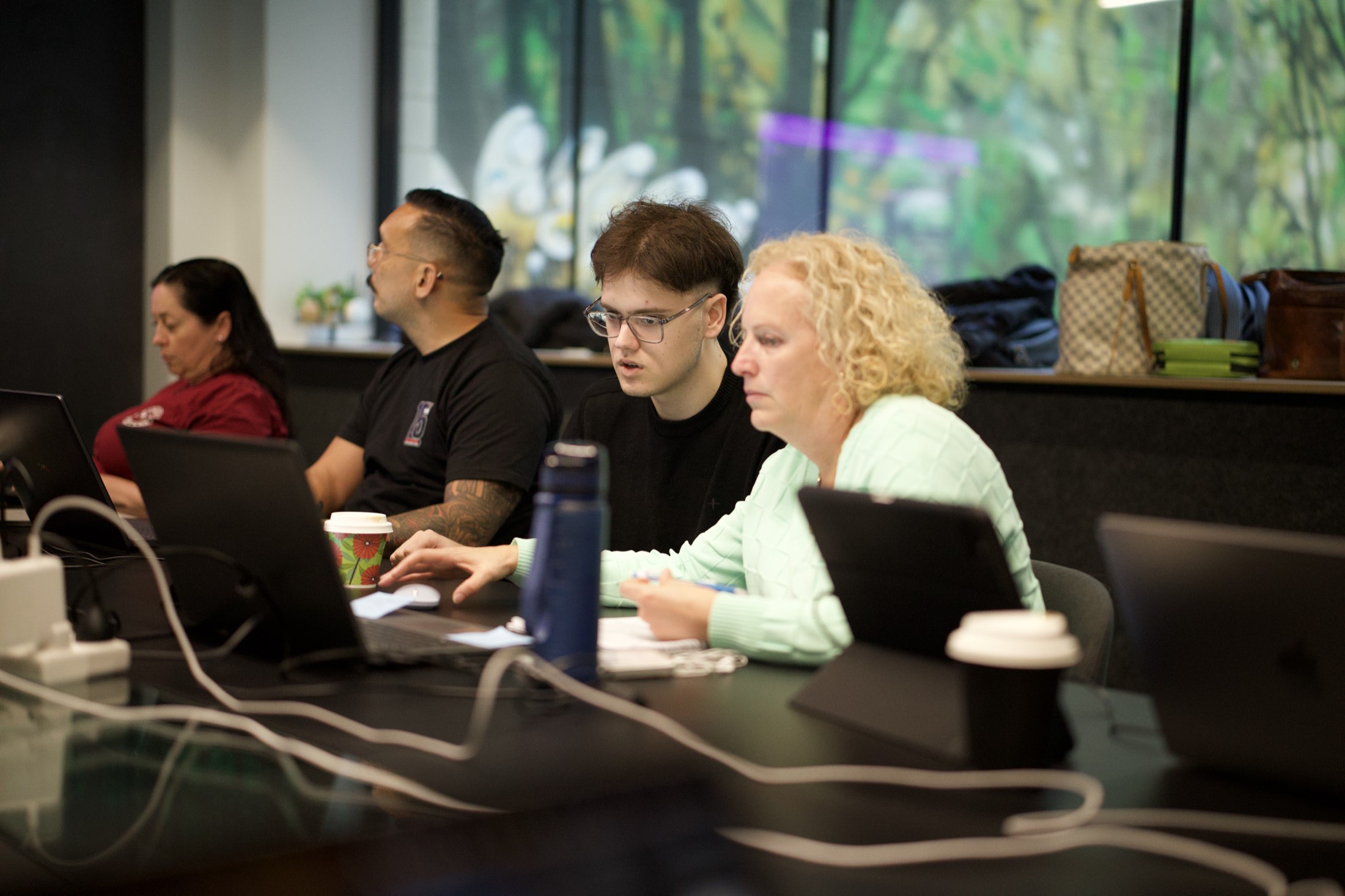 A Scalify trainer sitting beside a Perth team member practising ChatGPT at her laptop