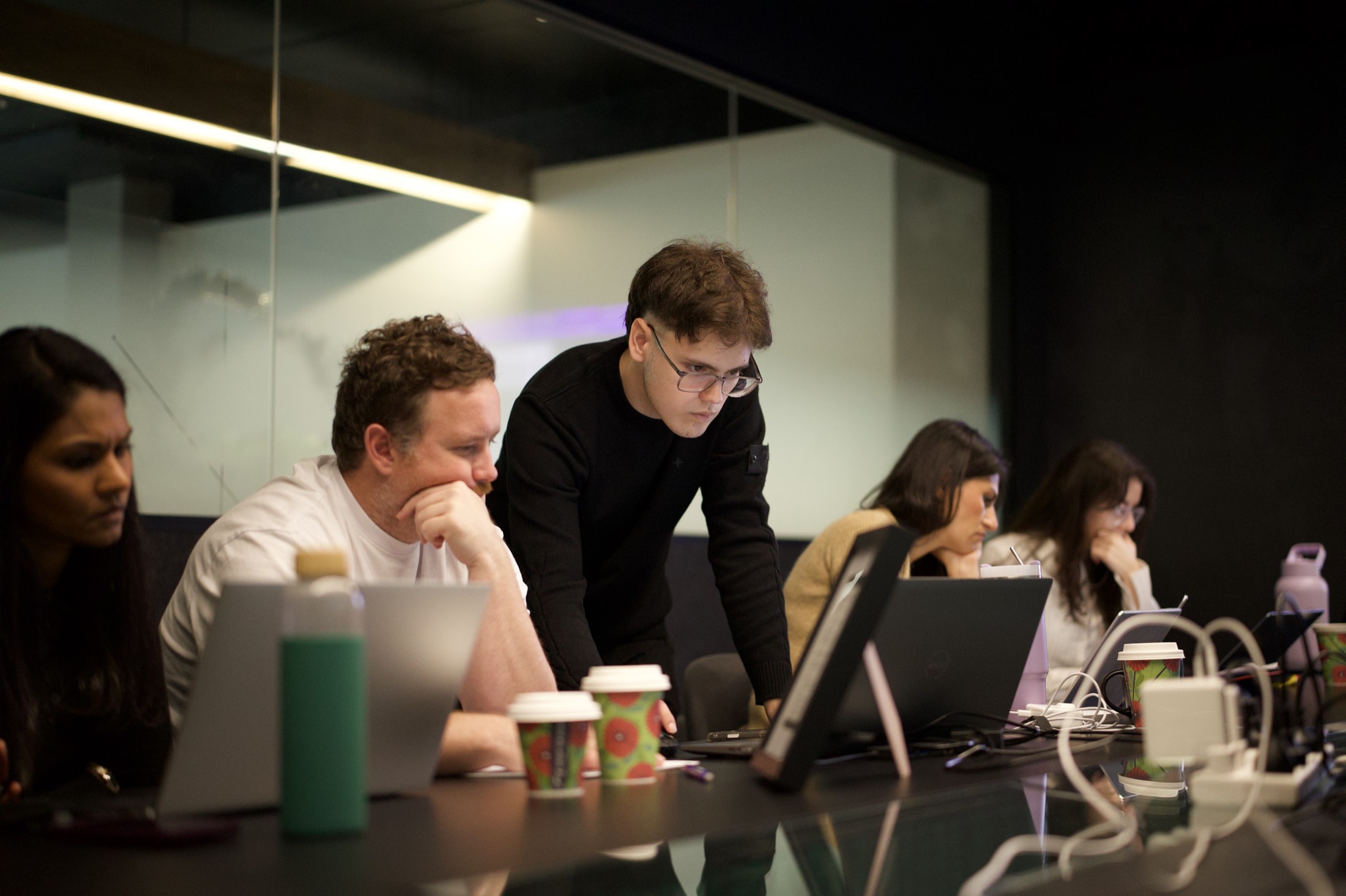 A Scalify trainer helping a Perth team work through Claude at their laptops