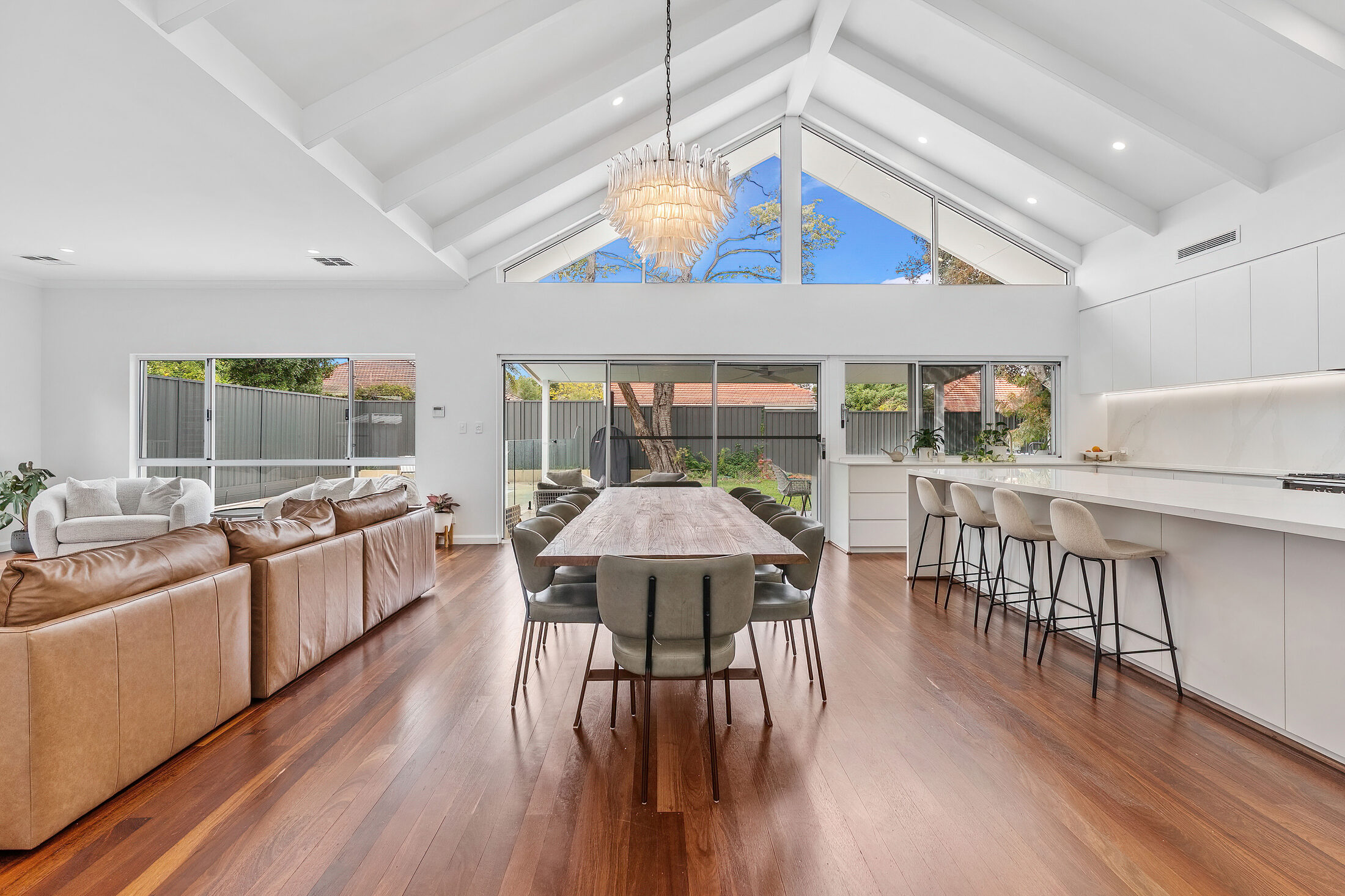 An open-plan living and dining room under a raked white ceiling, in a Perth home shown by Independent Building Advice