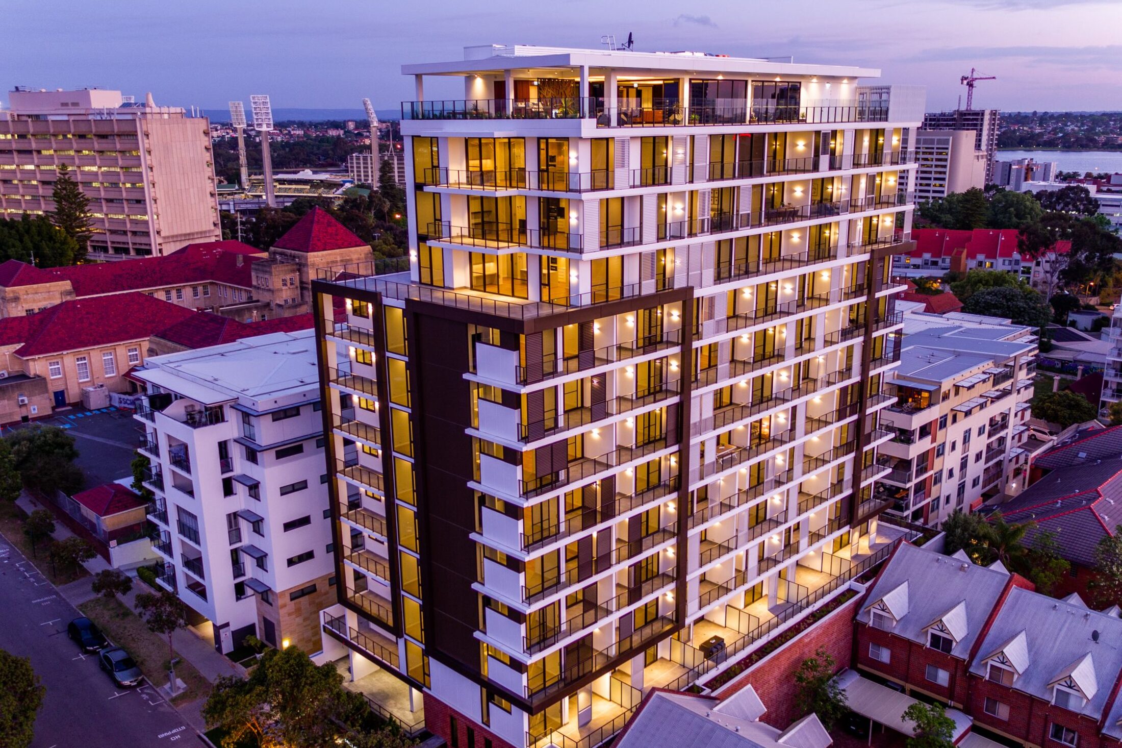Blackburne Enclave, a Perth residential tower with a glazed facade and aluminium windows by Vertex Facades, lit up at dusk